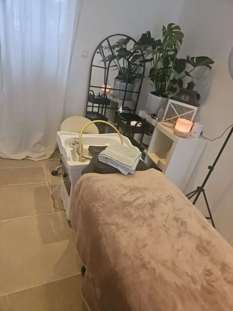Rustige behandelruimte van Skincare 23 in Borsbeek met head spa-wastafel, planten en kaarslicht